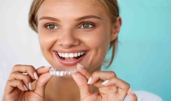 Picture of a woman, smiling at the camera, illustrating her happiness with the invisalign orthodontics procedure she had in Costa Rica.
